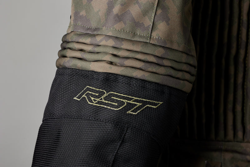 Närbild på ärmen av RST Textil Mc-Jacka Ranger Camo med RST-logotyp och elastiska paneler för rörelsefrihet.